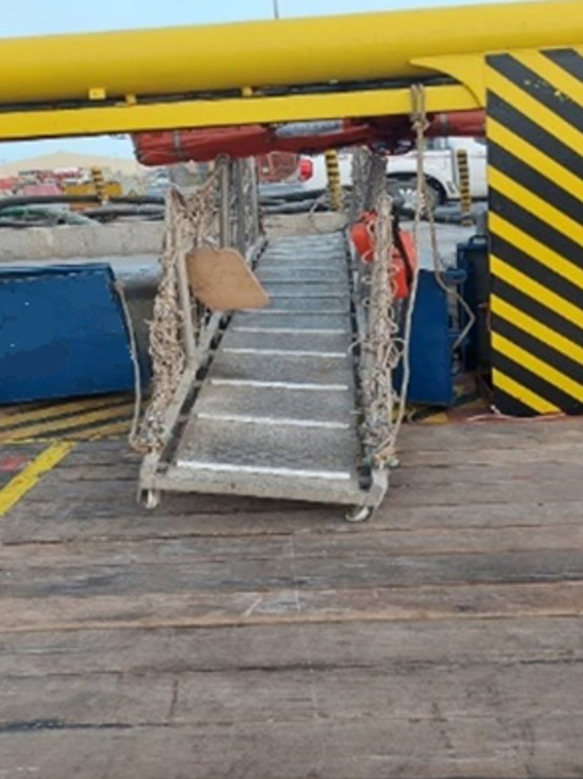 A Platform Supply Vessel was alongside loading deck cargo. The PSV suddenly started  moving alongside the jetty due to propeller wash  from another vessel passing nearby. A passing  workman on the quayside observed that the  gangway had got stuck over a quayside bollard and  was getting deformed by the vessel movement. He  released the gangway rope and informed the  gangway watch. The gangway was recovered to the  vessel. It was found that it was significantly  damaged.